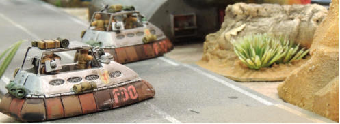 Two combat cars cross the road