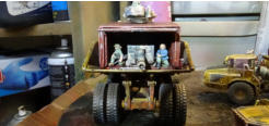 Rear of the shipping container of the dump truck with powergun and crew