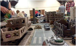 Blower and Tank destroyer face off while a buzzbomb team in the building, left, fire down from the first floor window