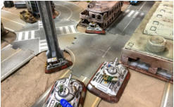 Blower looses a main gun (blue token) while a Legion APC shoots at a Combat Car from the rear. All take infantry attacks from the adjacent buildings