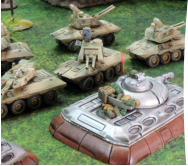 Blower tank drives past some Arcatinus AA system vehicles from Clarks Commandos