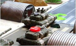 Two lead vehicles under attack - an NU-PDF Mace Heavy Tank loses its main gun to cannon fire while the other is swarmed by ATGWs